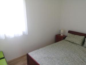 a small bedroom with a bed and a window at Ikerdió faházikó in Szarvas