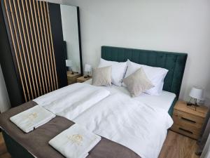 a large bed with white sheets and pillows on it at Mrakovica 1935 in Prijedor