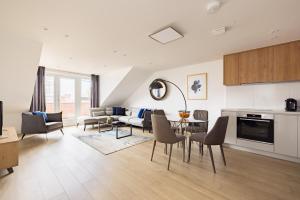 a kitchen and living room with a table and chairs at Staines City Centre by Charles Hope in Staines