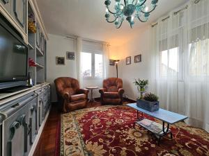 uma sala de estar com duas cadeiras e uma televisão em Casa Lantoxana 1A121 em Gijón