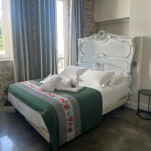 a bedroom with a white bed with a green and white blanket at Kemani Villa Sara Olbia in Olbia