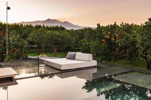 a white couch sitting on top of a glass table at Zash Country Boutique hotel & SPA in Giarre