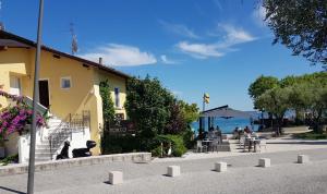 Un groupe de personnes assises à des tables près de l'eau dans l'établissement Graziosa Al Porto, à Moniga del Garda