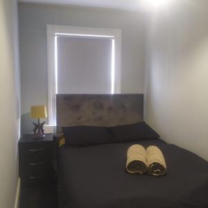 a bedroom with a black bed with a window at The Old White Hart Brewery Guesthouse in Bath