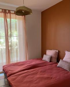 een slaapkamer met een groot rood bed en een raam bij Casa sardine in Cassis