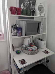 a shelf with a microwave and cups on it at Hawarden near Chester in Hawarden