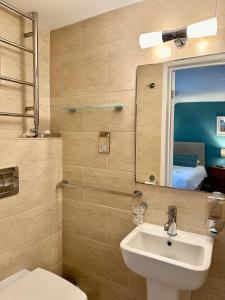 a bathroom with a sink and a toilet and a mirror at St George's Hotel in Perranporth