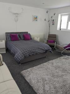 a bedroom with a bed with purple pillows at Hawarden near Chester in Hawarden
