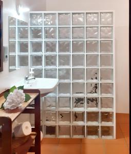 a bathroom with a wall of glass dividers at One bedroom house with enclosed garden and wifi at Parada in Parada