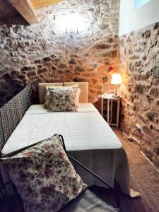 a bedroom with two beds and a stone wall at One bedroom house with enclosed garden and wifi at Parada in Parada