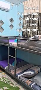 2 łóżka piętrowe w pokoju ze ścianą w obiekcie Maktok's Nilai Homestay w mieście Nilai