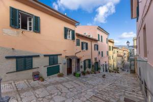 an alley in an old town with green shutters at Il Nido di Bianca - Goelba in Portoferraio