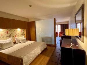 a hotel room with a bed and a living room at Apartamentos Turisticos Atlantida in Funchal