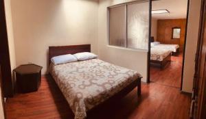 1 dormitorio con cama y espejo en ALOJAMIENTOS HOSTAL REST HOUSE, en Cuenca