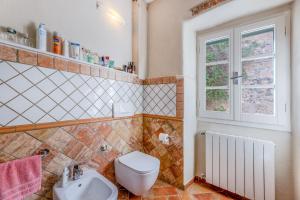 a bathroom with a toilet and a sink and a window at Il Nido di Bianca - Goelba in Portoferraio +10 photos