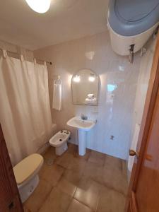uma casa de banho com um WC, um lavatório e um WC. em Apartamentos Góndolas V.v. em La Manga del Mar Menor