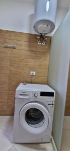 a washing machine in a bathroom with a light at Oasis in Durrës
