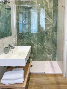 La salle de bains est pourvue d'un lavabo et d'une douche. dans l'établissement CasaMarì, à Torre del Greco