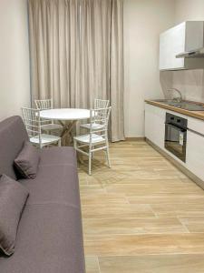 a living room with a kitchen and a table with chairs at CasaMarì in Torre del Greco +14 photos