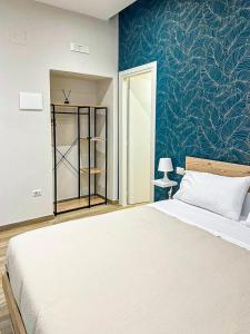 - une chambre avec un lit et un mur bleu dans l'établissement CasaMarì, à Torre del Greco