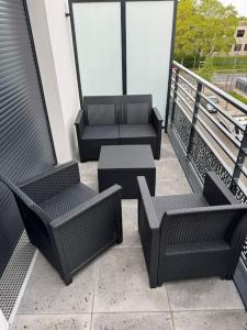 einen Balkon mit 3 Stühlen und einem Tisch auf einem Gebäude in der Unterkunft Odyssée - Appartement neuf Cergy in Cergy