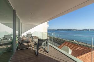 a balcony with chairs and a view of the ocean at Akicity Jamor Selected in Cruz Quebrada