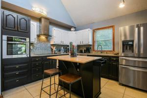 a kitchen with black cabinets and a wooden counter top at Rock and Roll River House in Jeffersonville