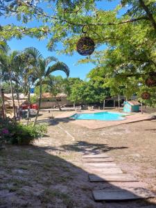 a swimming pool in a yard with trees at Pousada e Camping Solar de Itaunas in Itaúnas