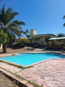 a swimming pool in front of a house at Pousada e Camping Solar de Itaunas in Itaúnas