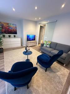 a living room with blue chairs and a couch at MONTALTINO 4 - CON GARAJE OPCIONAL- Céntrico, Cuidado, Acogedor - Cerca playas in A Coruña