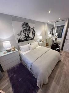 a bedroom with a large white bed and a mirror at MONTALTINO 4 - CON GARAJE OPCIONAL- Céntrico, Cuidado, Acogedor - Cerca playas in A Coruña