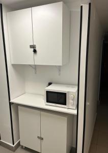 a white microwave on a shelf in a kitchen at Hostal Las Vegas in Madrid
