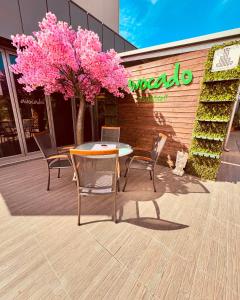 einen Tisch mit Stühlen und einen Baum mit rosa Blumen in der Unterkunft Plaza Hotel Plovdiv in Plowdiw