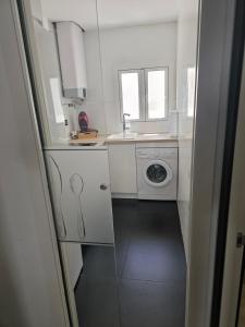 a white kitchen with a washing machine and a sink at Apartamento Luxury Home Huelva Zona centro in Huelva +21 photos