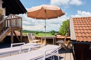 un patio con mesa y sombrilla en Appartement Alpine Affair, en Bad Feilnbach