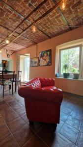 uma sala de estar com um sofá vermelho e uma mesa em Villa Aurora Sotto Le Stelle em Torre Pellice