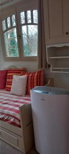 a small room with a bed and a refrigerator at Villa Rose in Escolives-Sainte-Camille