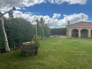 un patio con una casa y un tronco de árbol en Cordel, en La Serrada