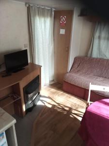 Kleines Zimmer mit einem Bett und einem TV in der Unterkunft Mobilní dům Venda in Hradišťko