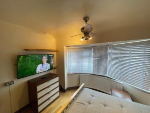 a living room with a couch and a flat screen tv at 2 Bed Flat near Heathrow Airport & Elizabeth Line in Hayes