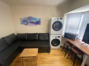a living room with a couch and a washing machine at 2 Bed Flat near Heathrow Airport & Elizabeth Line in Hayes +5 photos