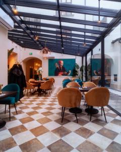 um restaurante com mesas e cadeiras num piso de xadrez em Hotel Pietryna em Łódź
