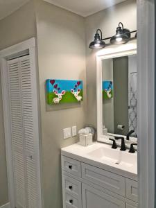ein Bad mit einem Waschbecken und einem Spiegel in der Unterkunft The John Randall House in Provincetown