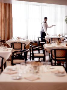 a man standing at a table in a restaurant at Aparthotel VIP Executive Suites do Marquês in Lisbon