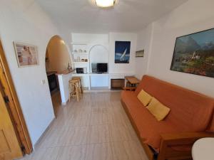 sala de estar con sofá y cocina en Apartamentos Góndolas V.v., en La Manga del Mar Menor