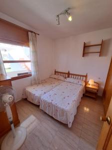 1 dormitorio con 2 camas y ventana en Apartamentos Góndolas V.v., en La Manga del Mar Menor