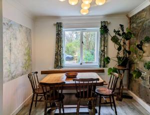 a dining room with a table and chairs and a window at Ty Madog Eryri Snowdonia in Cwm-y-glo