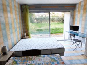 Schlafzimmer mit einem Bett, einem Schreibtisch und einem Fenster in der Unterkunft Studio avec vue sur la ville et terrasse amenagee a Brioude in Brioude