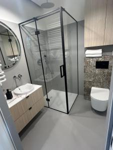 a bathroom with a shower and a toilet and a sink at Tutu Kraków Comfort in Krakow