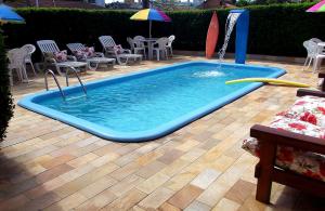 a pool with a surfboard in the middle of a patio at Dom Pedrito Apart Hotel in Florianópolis